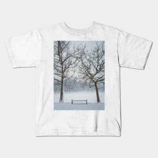 a bench under the snowy trees Kids T-Shirt